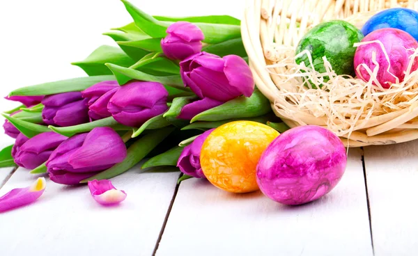 Easter eggs and bouquet tulips, on white wooden — Stock Photo, Image