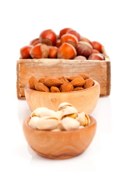 Almendras, pistachos y avellanas en los cuencos de madera — Foto de Stock