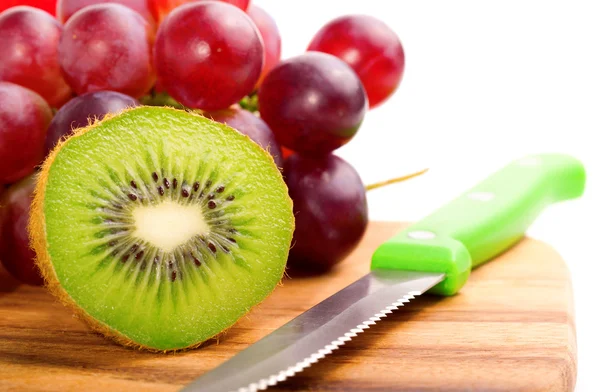 Single cross section of kiwi on grapes background, over whit — Stock Photo, Image