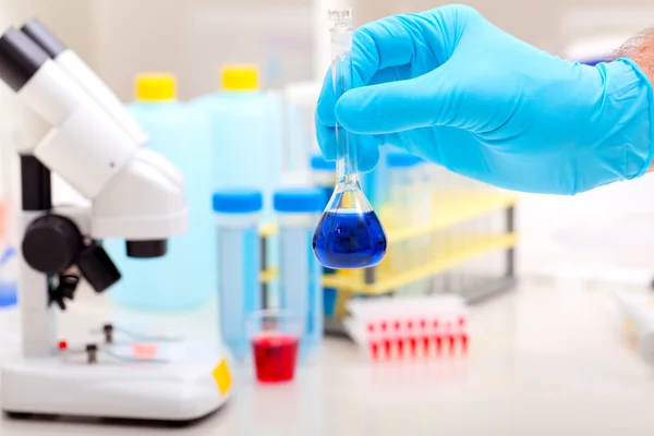 Pallone con liquido blu in mano. Laboratorio di ricerca scientifica — Foto Stock