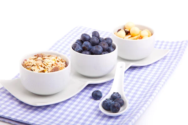 Fresh blueberry with porcelain spoon, corn flakes and serviette. — Stock Photo, Image