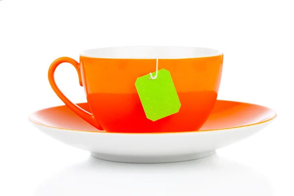 Taza de té naranja y bolsa de té verde. Aislado sobre fondo blanco —  Fotos de Stock