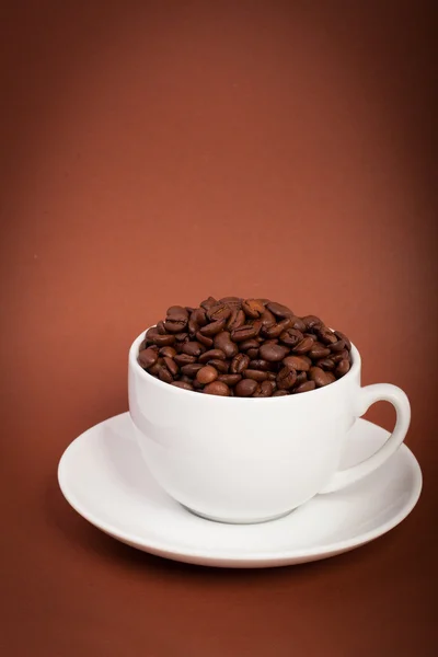 Taza con granos de café sobre un fondo oscuro — Foto de Stock