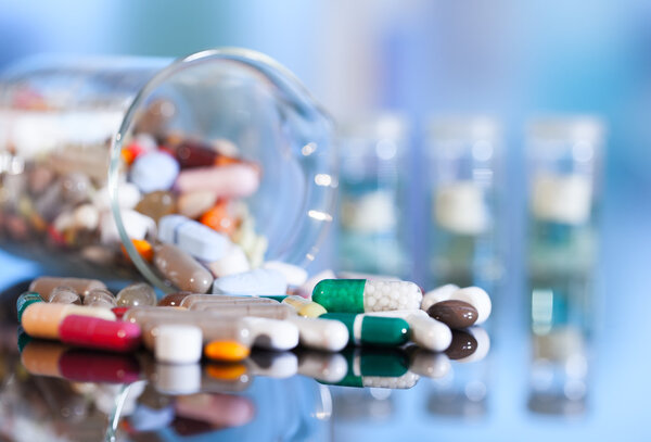 Красочные таблетки с капсулами и таблетками на синем фоне