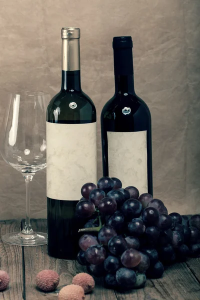Fles van wijnstokken op houten achtergrond — Stockfoto