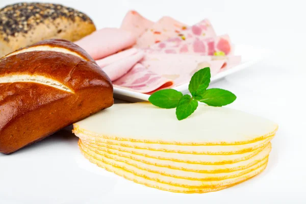 Rebanadas de queso, salchichas y bollo para el desayuno, aislados en blanco —  Fotos de Stock