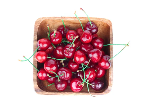 Bayas de cereza en cuenco de madera, aisladas sobre fondo blanco — Foto de Stock