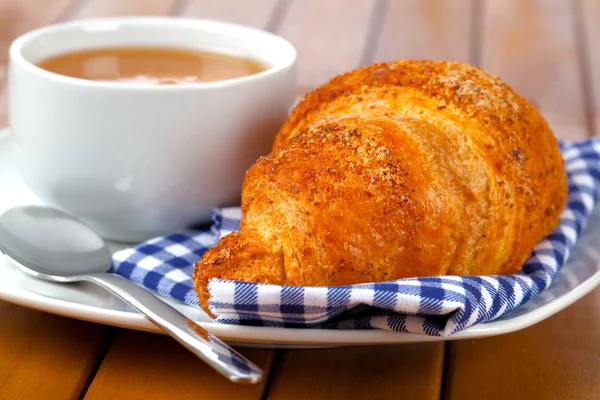 Croissant mit Marmelade und Kaffeebecher. auf Holzunterlage — Stockfoto