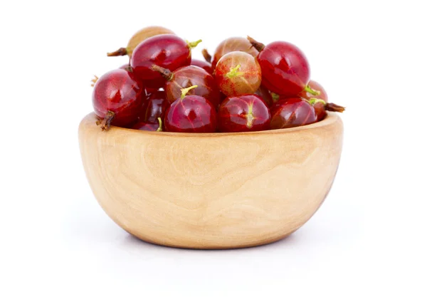 Fresh red gooseberries in a wooden bowl, over a white background — Stock Photo, Image