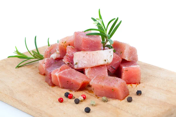Кусочки сырого мяса на кухонной доске, на белом фоне — стоковое фото
