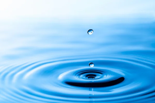 Splash de coroa de água na superfície azul — Fotografia de Stock