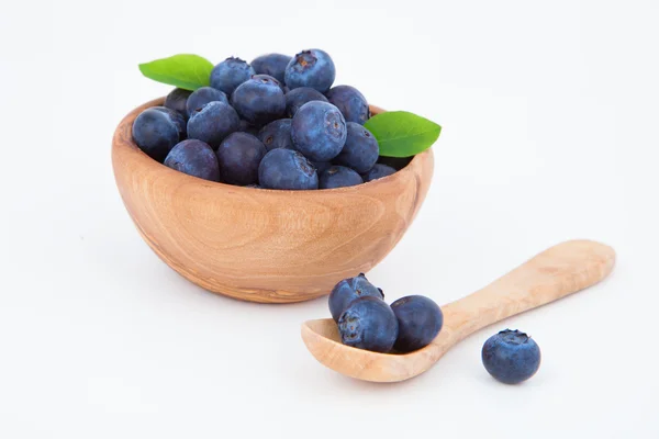 在一个木碗，在白色背景的新鲜蓝莓. — 图库照片