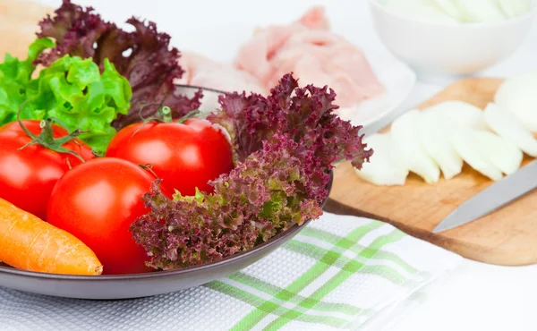 Tomates e salada verde na tigela, na mesa — Fotografia de Stock