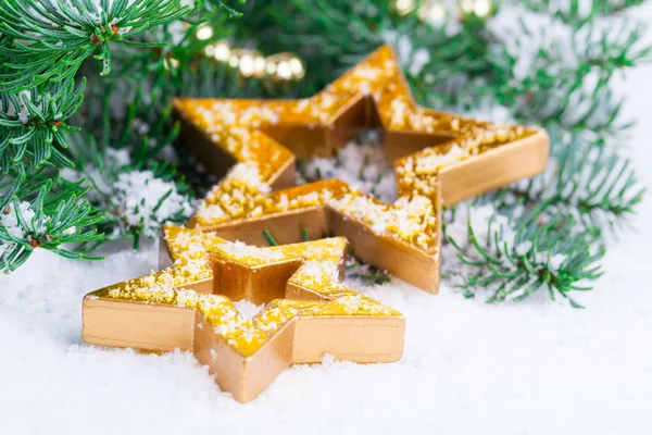 Golden Christmas stars with pine branch and snow — Stock Photo, Image