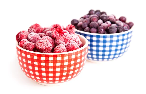 Frozen raspberries and bilberries in the bowl, on a white backgr — Stock Photo, Image