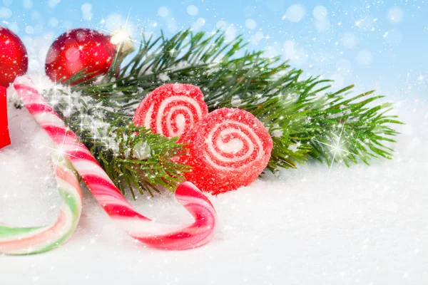 Decoração de Natal com bastões de doces, em um fundo de neve falso — Fotografia de Stock