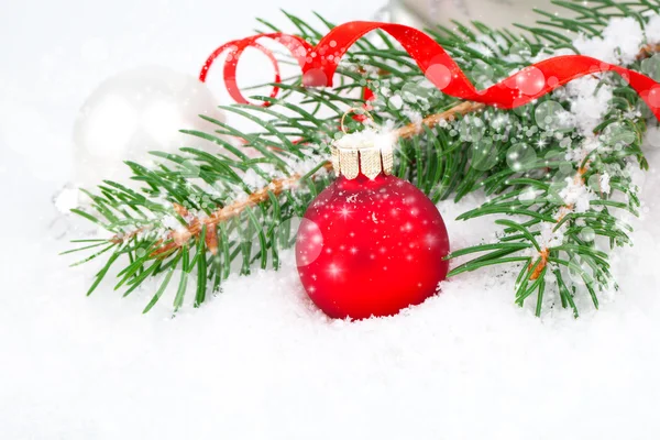 Weihnachtskugeln und Tannenzweige auf schneebedecktem Hintergrund. — Stockfoto