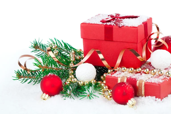Regalo rojo de Navidad con decoraciones festivas sobre fondo de nieve —  Fotos de Stock