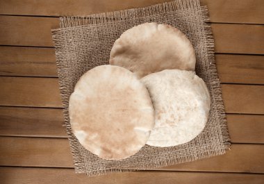pitta bread (Lebanese Bread), over old burlap background clipart