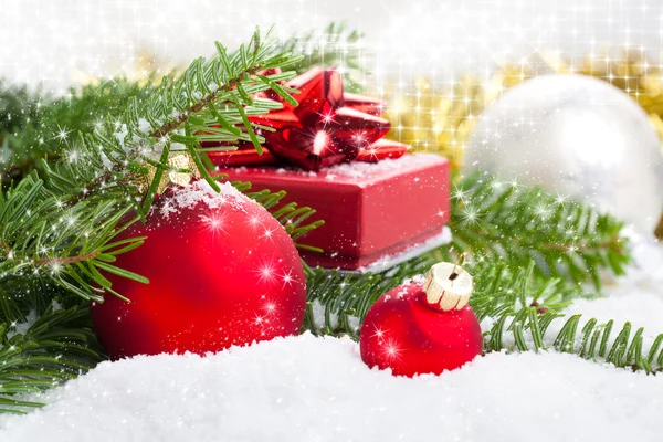 Çam dalı, hediye ve kar beyaz sno üzerinde kırmızı Noel top — Stok fotoğraf