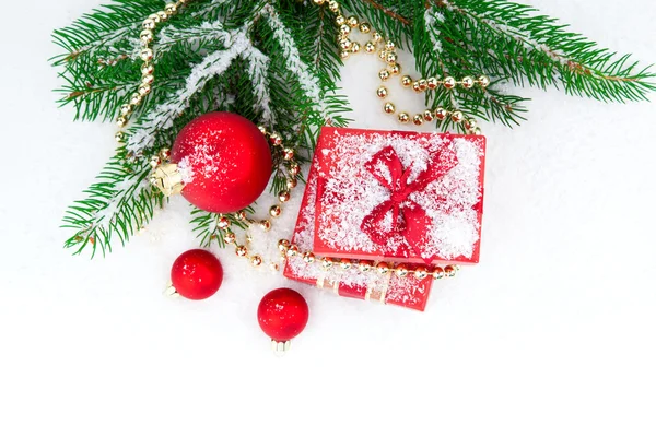 Weihnachtsgeschenk und Kugeln auf Tannenzweigen, über weiß — Stockfoto