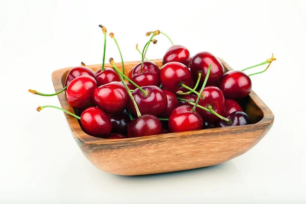 Bayas de cereza en cuenco de madera, aisladas sobre fondo blanco —  Fotos de Stock