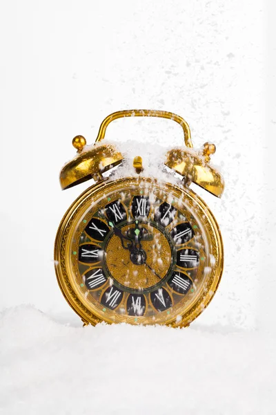 Antique gold clock in the snow. with copy space on a white backg — Stock Photo, Image