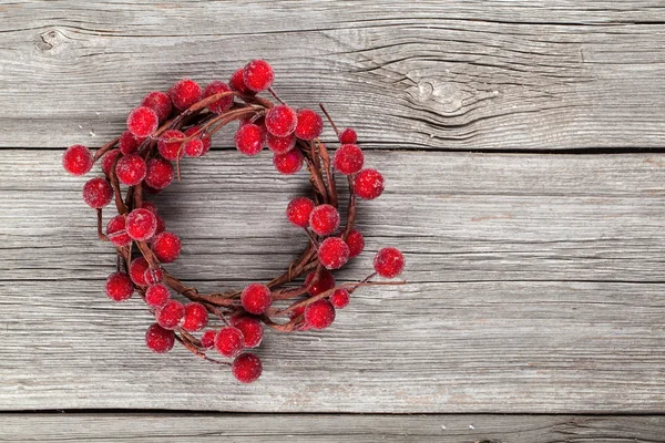 Christmas wreath from red berries on wooden background — Stock Photo, Image