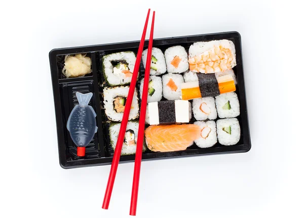 Delicious sushi rolls on white plate with chopsticks — Stock Photo, Image