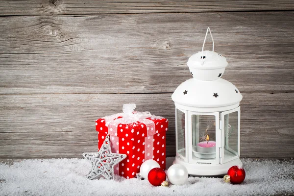 Brennende Laterne im Schnee mit Weihnachtsdekoration, auf Holz — Stockfoto