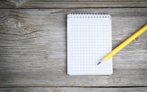 Notepad on a wooden table with pencil — Stock Photo, Image