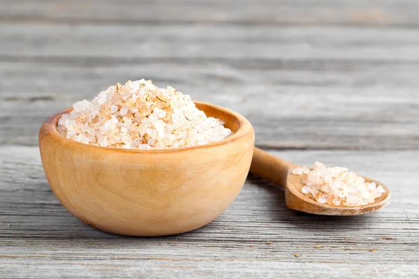 Pink salt  in the wooden bowl, on wooden board — Stock Photo, Image