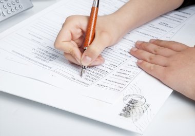 filling the documents. Hand with pen over blank  clipart