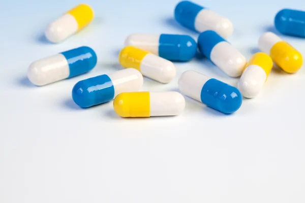 Kleurrijke medische capsules op witte achtergrond. — Stockfoto
