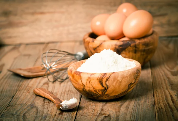 Farinha e ovos, ingredientes para assar. sobre fundo de madeira — Fotografia de Stock