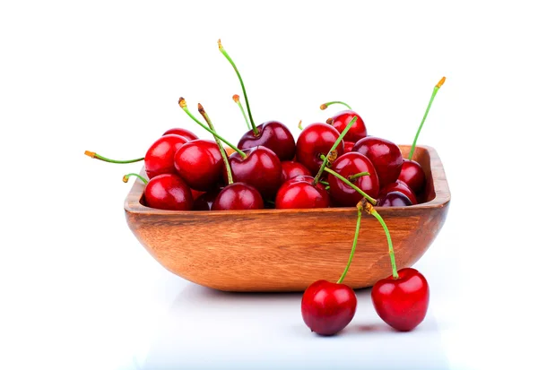 Bayas de cereza en cuenco de madera, aisladas sobre fondo blanco — Foto de Stock