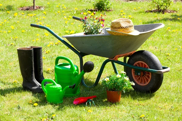 Gardening tools and a straw hat on the grass in the garden — Stock Photo, Image