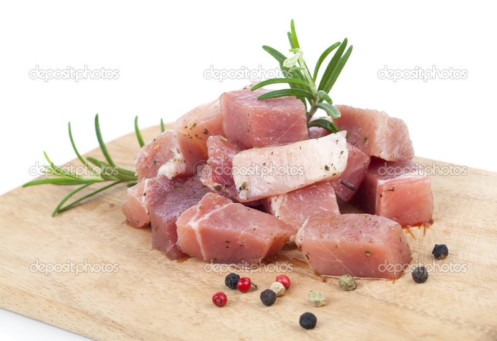 pieces of raw meat on a kitchen board, on a white background