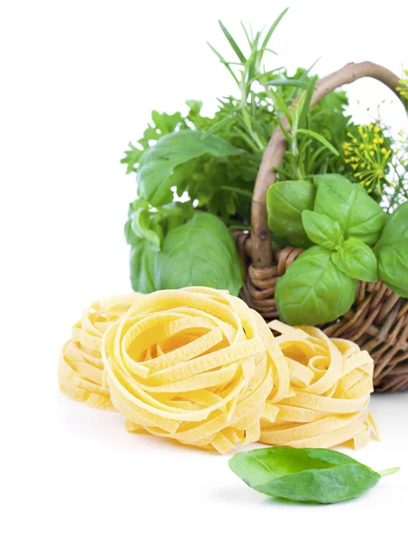 Ninho de macarrão italiano fettuccine com folhas de manjericão fresco, em branco — Fotografia de Stock