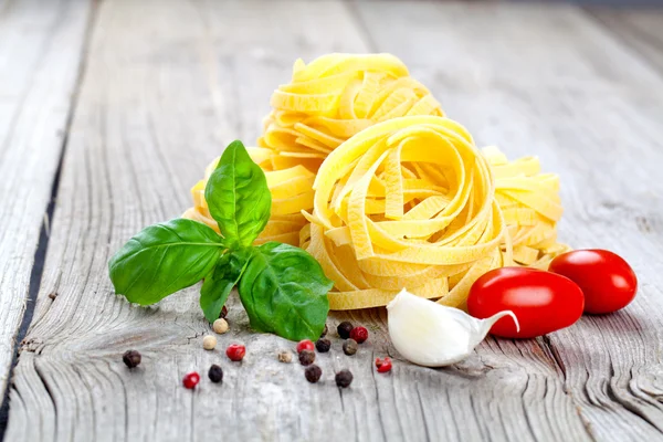 Italienische Pasta fettuccine Nest mit Knoblauch, Tomaten und frischem Ba — Stockfoto