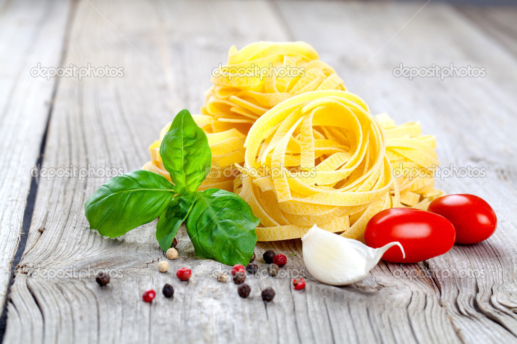 Italian pasta fettuccine nest with garlic, tomatoes and fresh ba