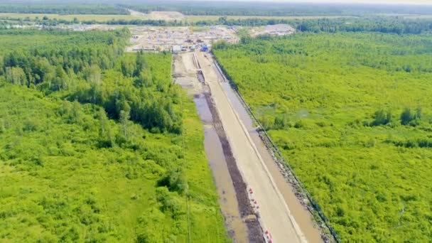 鬱蒼とした緑の森の中に新しい高速道路の大規模な建設のトップビュー ロイヤリティフリーのストック動画