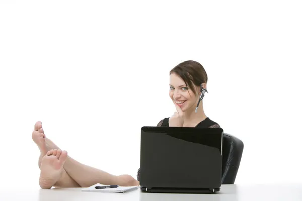 Ayakları ile üzerine beyaz izole masasında oturan iş kadını — Stok fotoğraf