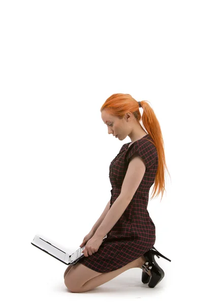 Woman kneeling reading her laptop — Stock Photo, Image