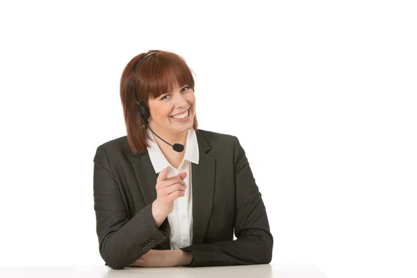 Smiling call centre operator pointing at the lens — Stock Photo, Image