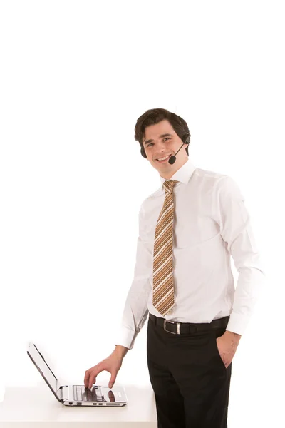 Affärsman bära ett headset på sin laptop — Stockfoto
