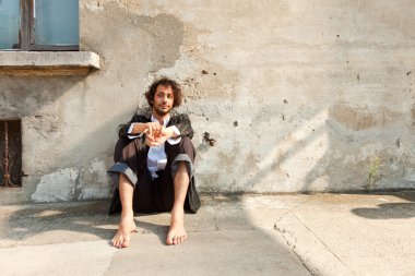 bir duvarın önünde oturan çocuk