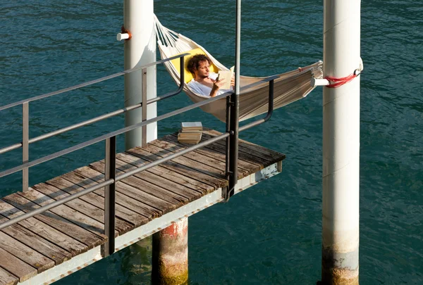 Menino lendo em hamaca — Fotografia de Stock