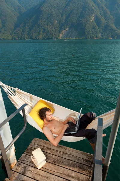 Boy working on hamaca on the lake — Stock Photo, Image