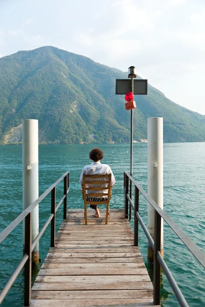 Boy back overlooking the lake — Stock Photo, Image